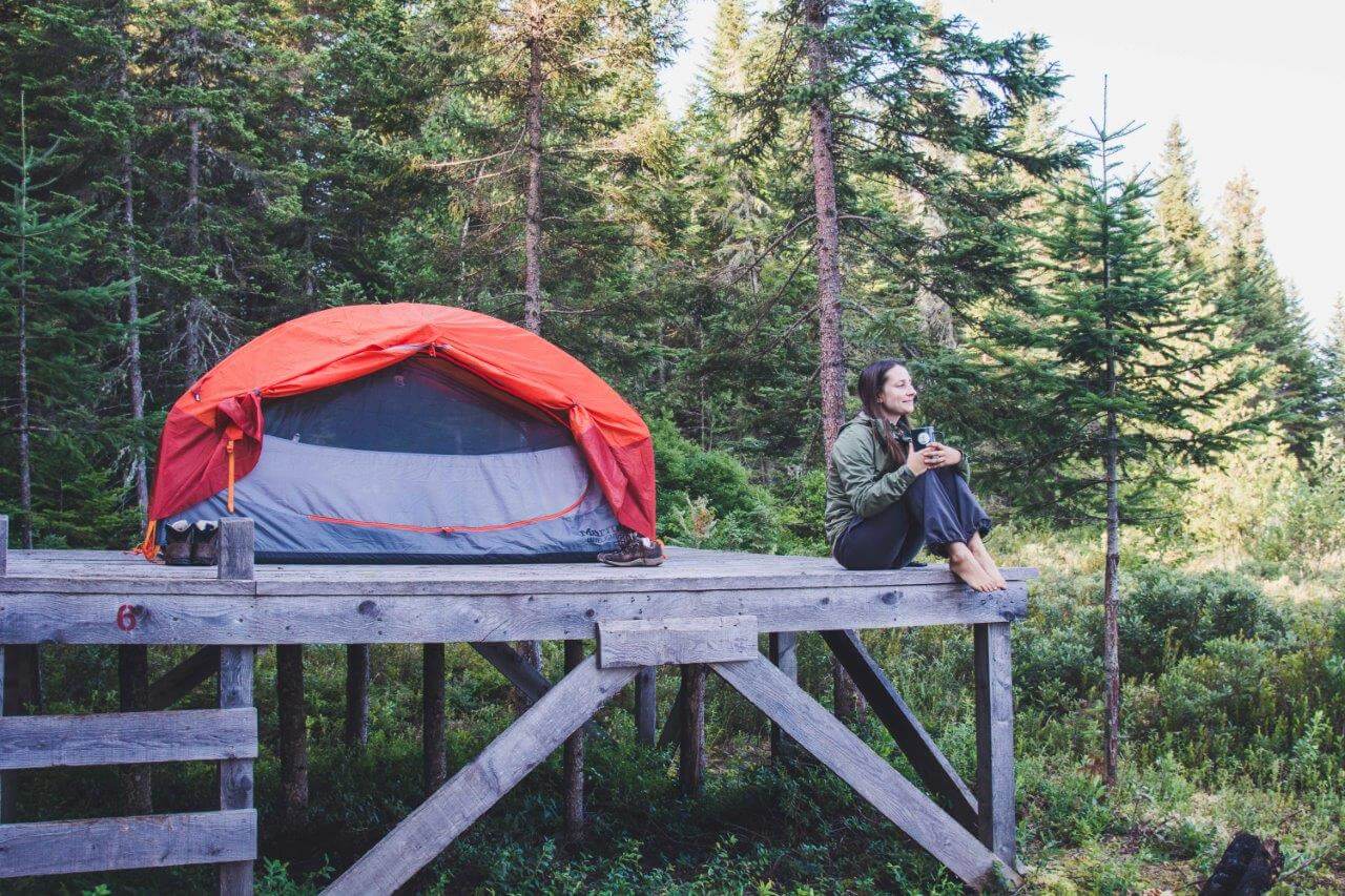 femme installée avec sa tente de camping sur une Zec